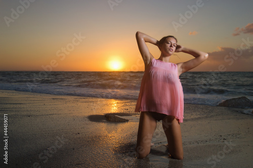 Photo: Ragazza in posa sulla riva del mare al tramonto Ragazza in posa sulla riva del mare al tramonto