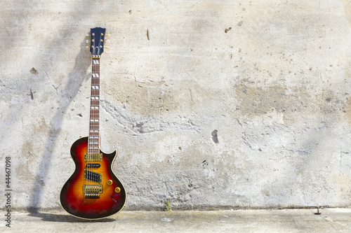  electric guitar in front of a vintage wall
