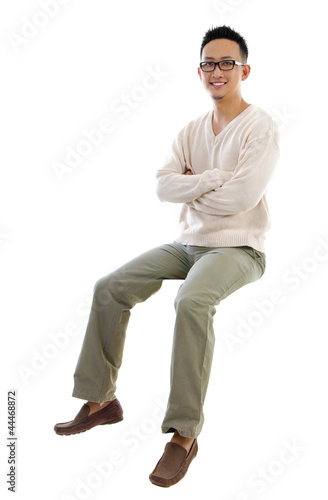 Photo: Full body Asian man sitting on a transparent block Full body Asian man sitting on a transparent block