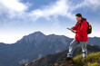 Photo: young man touching the tablet pc on the top of mountain young man touching the tablet pc on the top of mountain