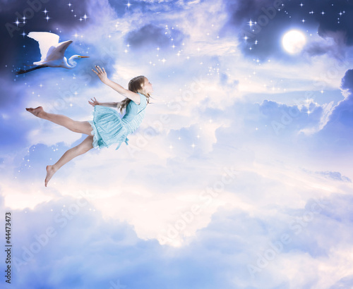 Photo: Little girl flying into the blue night sky Little girl flying into the blue night sky