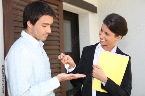Foto: Estate agent handing over the keys to a new home Estate agent handing over the keys to a new home