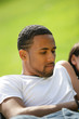 Young man relaxing on the grass with friends