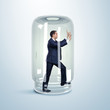 Businessman inside glass jar