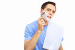 Young man at home shaving himself