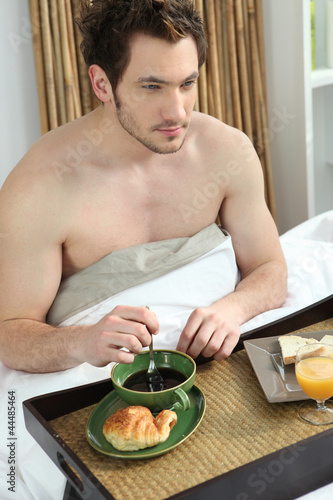 Photo: man having breakfast in bed man having breakfast in bed