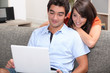 Couple watching film on laptop computer at home