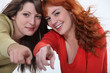 Two attractive women pointing fingers