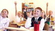 Adorable children raising their hands during the lesson
