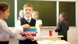 Smart schoolboy holding books and  classmates taking them