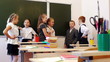 Schoolchildren standing near the blackboard and chatting