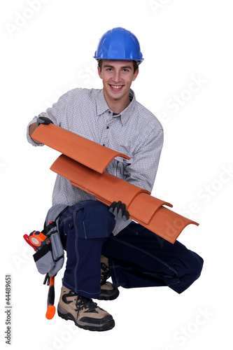 Photo: Worker holding roof shingles Worker holding roof shingles