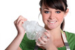 young girl squashing plastic bottle