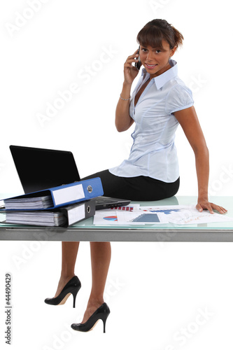 Photo: Woman sitting on the table in the office Woman sitting on the table in the office