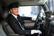 Handsome chauffeur driving limousine smiling