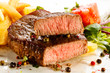 Grilled steaks, French fries and vegetables