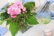A dining table decorated with a simple flower arrangement