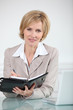 Businesswoman writing in diary