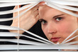 Woman looking through blinds