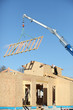 Crane lifting a wooden structure