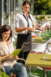 Woman checking menu waitress bringing order coffee