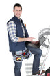 Happy electrician with his equipment on white background