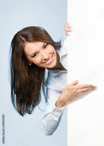 Photo: Businesswoman showing signboard, over blue Businesswoman showing signboard, over blue