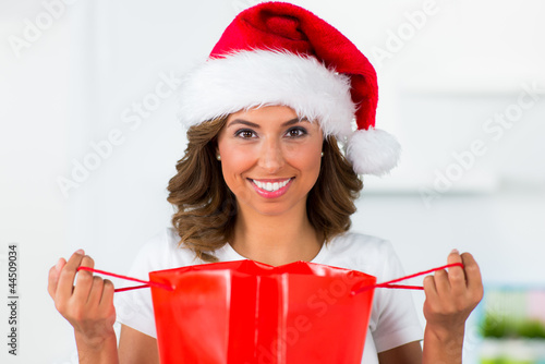 Photo: junge frau öffnet ihre nikolaustüte junge frau öffnet ihre nikolaustüte