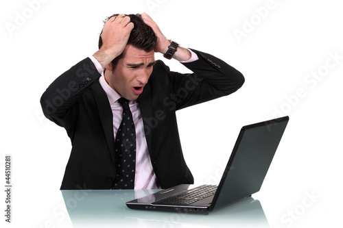Photo: A businessman pissed at his laptop. A businessman pissed at his laptop.