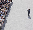 Businessman with bullhorn talking to crowd of people