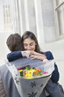 Woman hugging man with flowers behind back