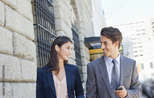 Photo: Businessman and businesswoman walking in city Businessman and businesswoman walking in city