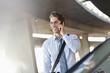 Smiling businessman talking on cell phone in parking garage