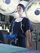 Portrait of confident nurse holding kidney dish under surgical lights