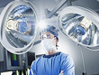 Serious surgeon under surgical lights