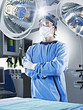 Portrait of serious surgeon with arms crossed under surgical lights