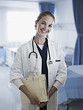 Portrait of confident doctor holding medical record in hospital room