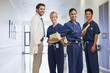 Portrait of smiling doctor and nurses in hospital corridor