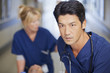 Close up of serious nurse pushing patient down hospital corridor