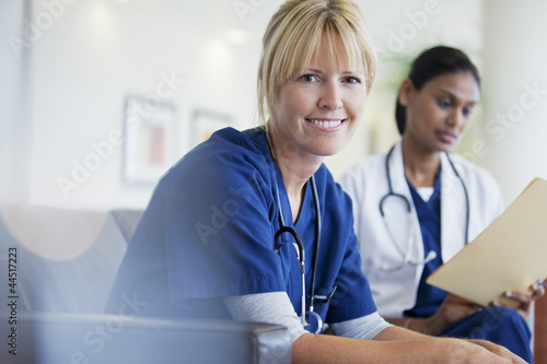 Photo: Portrait of smiling nurse sitting with doctor in hospital Portrait of smiling nurse sitting with doctor in hospital