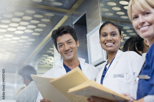 Photo: Portrait of smiling doctors and nurse with medical records Portrait of smiling doctors and nurse with medical records