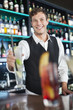Portrait of smiling bartender holding cocktail