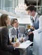 Sommelier presenting wine bottle to couple in restaurant