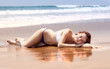 beautiful girl sunbathes on an ocean coast