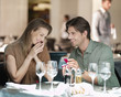 Man with engagement ring proposing to woman in restaurant