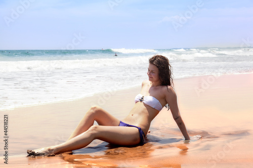 Photo: beautiful girl sunbathes on an ocean coast beautiful girl sunbathes on an ocean coast