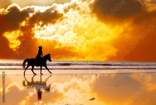 Photo: Silhouette of girl skipping on a horse on a sunset Silhouette of girl skipping on a horse on a sunset