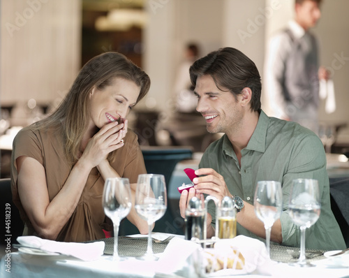 Photo: Man with engagement ring proposing to woman in restaurant Man with engagement ring proposing to woman in restaurant