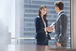 Smiling businessman and businesswoman shaking hands on urban balcony