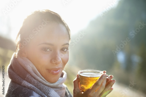 Photo: Portrait of smiling woman in scarf drinking cider Portrait of smiling woman in scarf drinking cider
